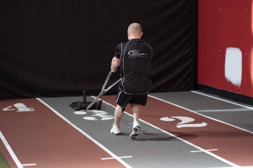 Backward Sled Drag demonstration, start of the movement, targeting the quads