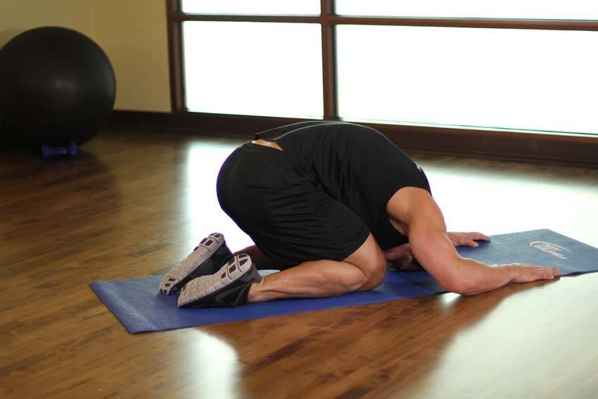 Child's Pose demonstration, start of the movement, targeting the back