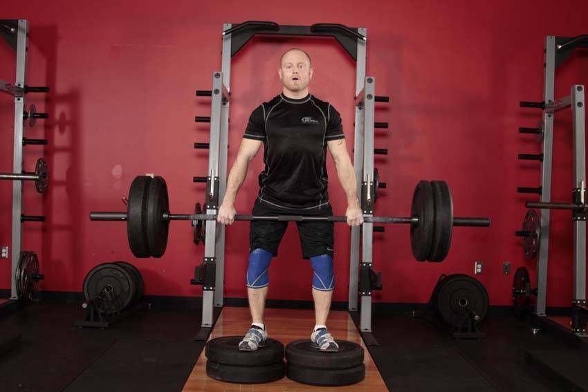 Deficit Romanian Deadlift demonstration, start of the movement, targeting the hamstrings
