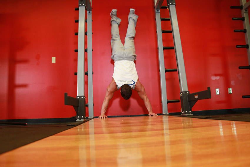 Wall Handstand Push-Up demonstration, start of the movement, targeting the shoulders