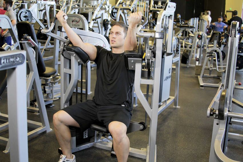 Machine Biceps Curl demonstration, start of the movement, targeting the biceps