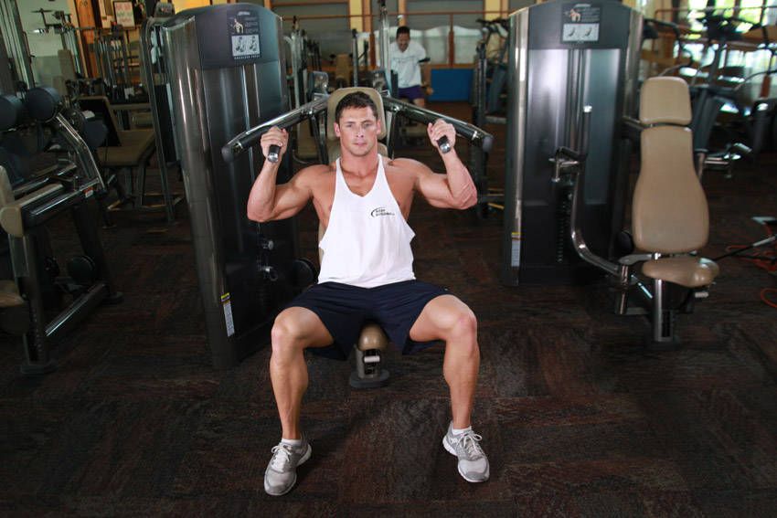 Machine Shoulder Press demonstration, start of the movement, targeting the shoulders