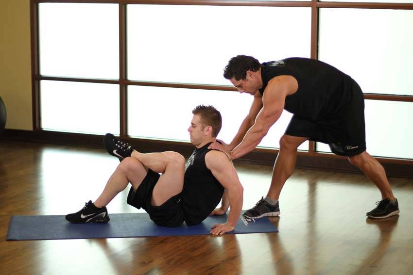 Seated Glute Stretch demonstration, start of the movement, targeting the glutes